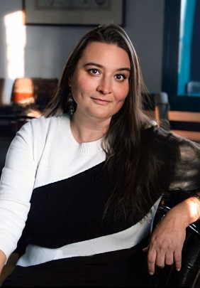 Women with brown hair wearing a white and black striped top.