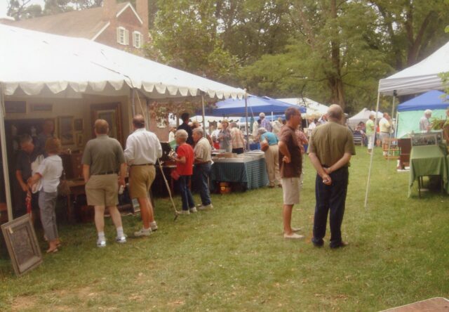 people are looking at antique items under tents outdoors